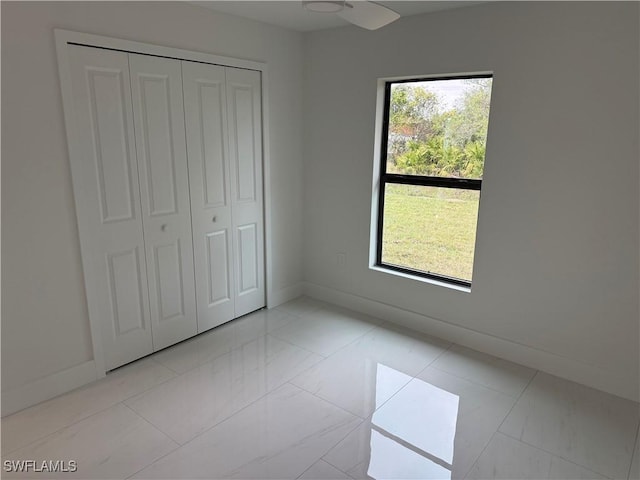 unfurnished bedroom with light tile patterned floors, a closet, and multiple windows