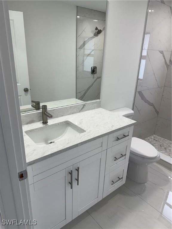 bathroom featuring toilet, vanity, and a tile shower