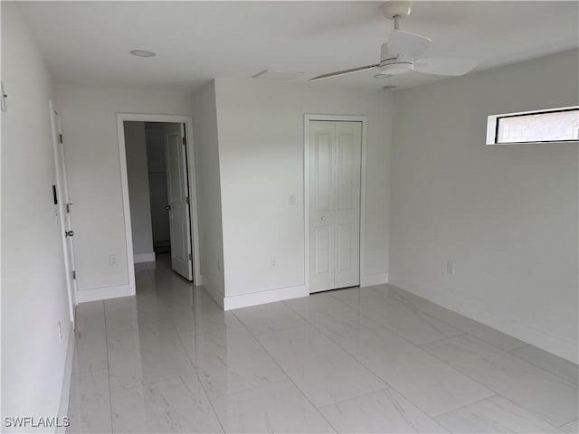 unfurnished bedroom with ceiling fan and a closet