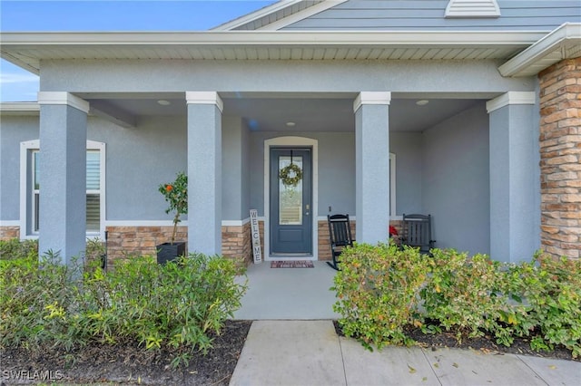 view of exterior entry featuring covered porch