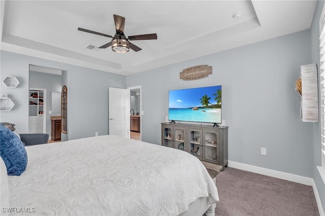 bedroom featuring ceiling fan, carpet floors, and a tray ceiling