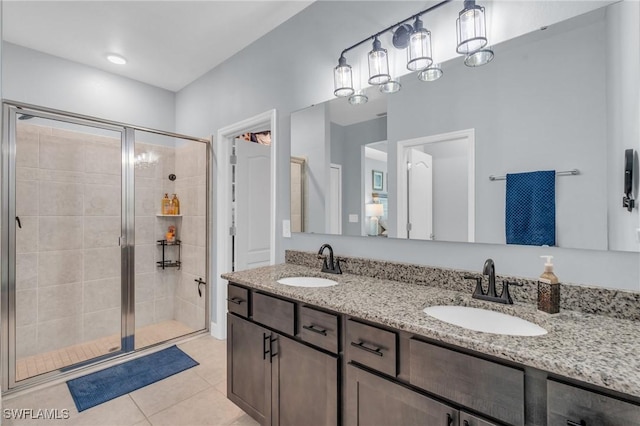 bathroom with a shower with shower door, vanity, and tile patterned floors