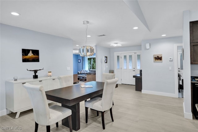 dining space with a notable chandelier and light wood-type flooring