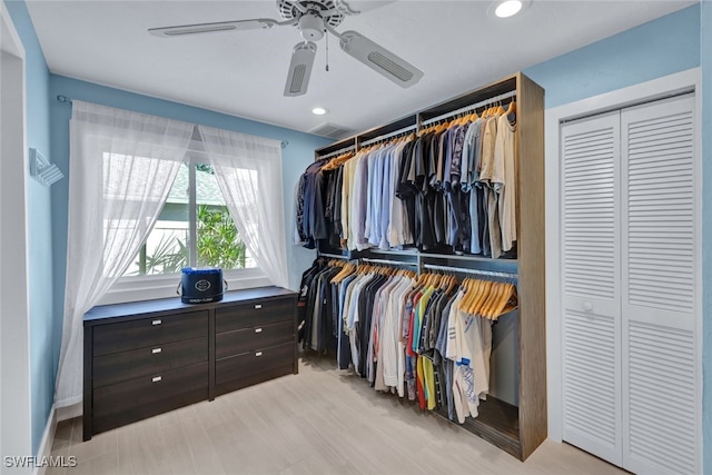 walk in closet with ceiling fan