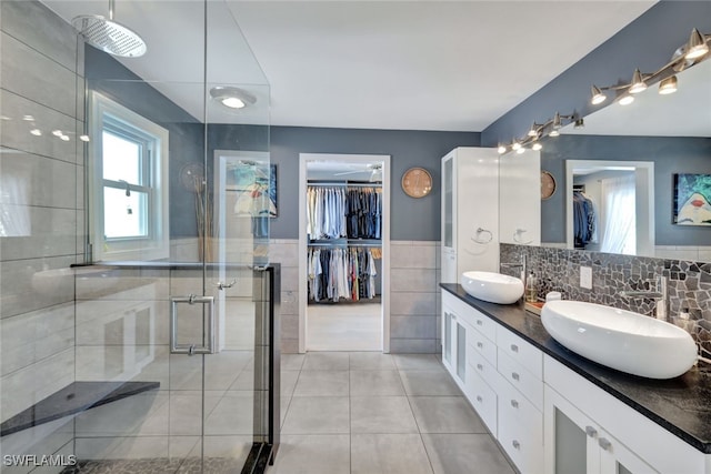 bathroom featuring tile patterned flooring, vanity, tile walls, and an enclosed shower