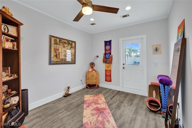 entrance foyer featuring crown molding, ceiling fan, and light hardwood / wood-style flooring