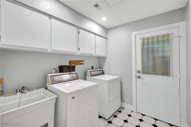 laundry room with sink, washer and clothes dryer, and cabinets