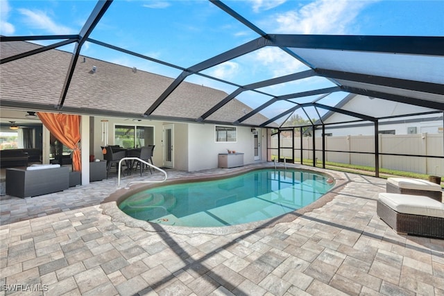 view of swimming pool with outdoor lounge area, glass enclosure, and a patio area