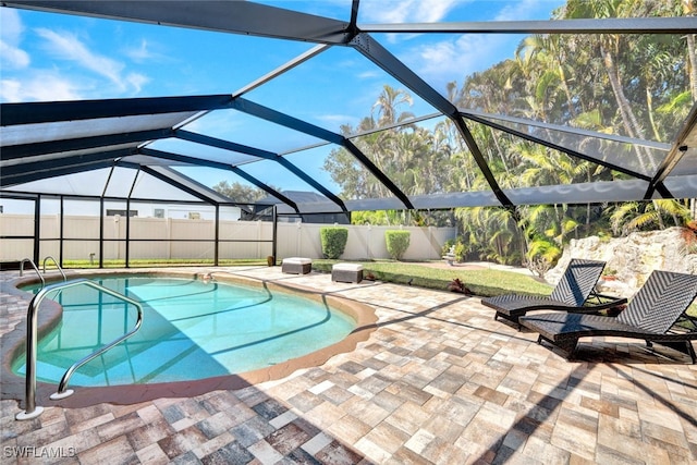 view of swimming pool with glass enclosure and a patio