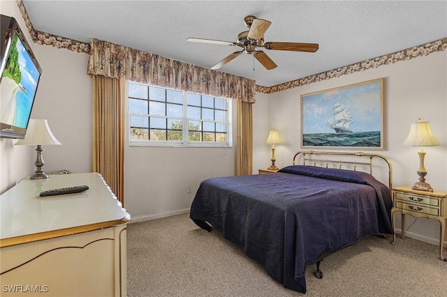 carpeted bedroom with ceiling fan and a textured ceiling