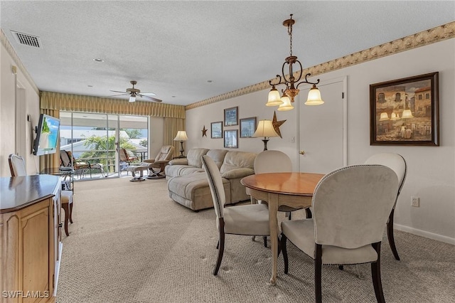 dining area featuring ceiling fan, light carpet, and a textured ceiling