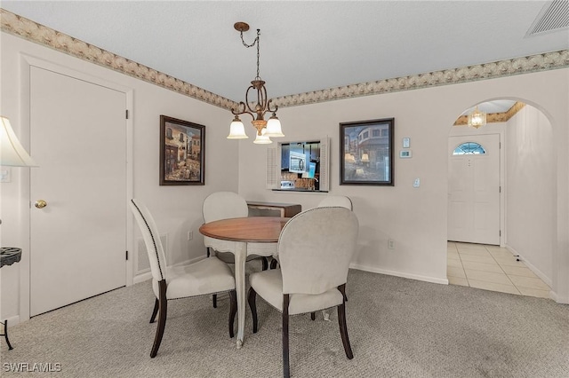 carpeted dining space featuring a notable chandelier