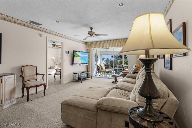 living room featuring ceiling fan, light carpet, and a textured ceiling