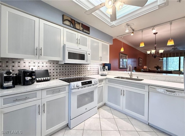 kitchen with track lighting, sink, white cabinetry, and white appliances