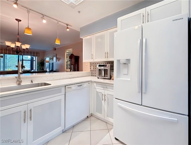 kitchen with light tile patterned floors, decorative light fixtures, white appliances, white cabinets, and sink