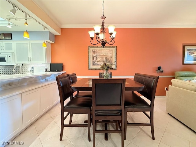 tiled dining space featuring crown molding and an inviting chandelier