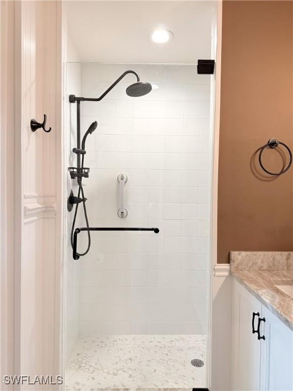 bathroom with vanity and a tile shower