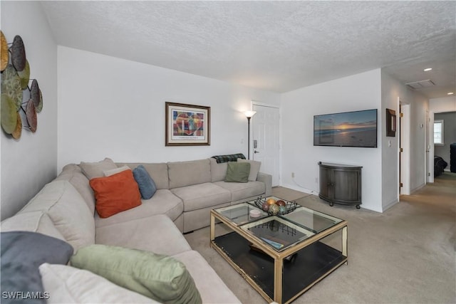 living room with a textured ceiling and light colored carpet