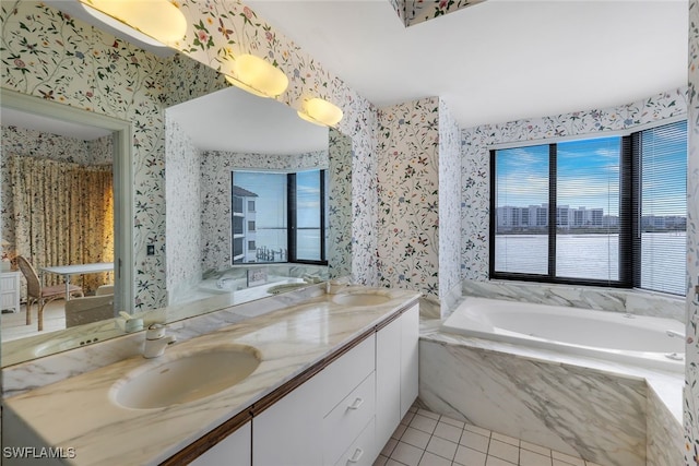 bathroom featuring a relaxing tiled tub, vanity, and tile patterned flooring