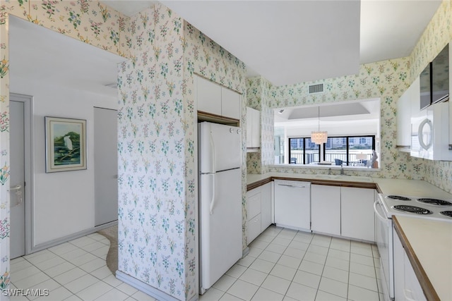 kitchen featuring white appliances, white cabinetry, sink, hanging light fixtures, and light tile patterned floors