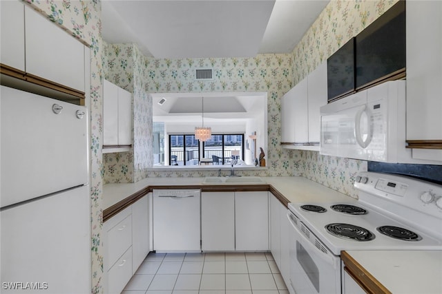 kitchen featuring white appliances, white cabinetry, hanging light fixtures, light tile patterned floors, and sink