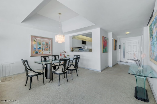 dining area with light colored carpet, radiator, a raised ceiling, and an inviting chandelier