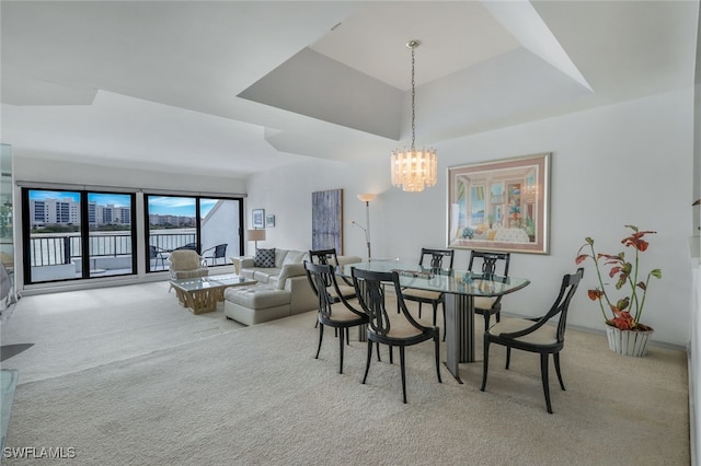 dining area with a chandelier and light colored carpet