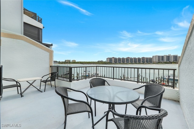 view of patio / terrace with a balcony and a water view