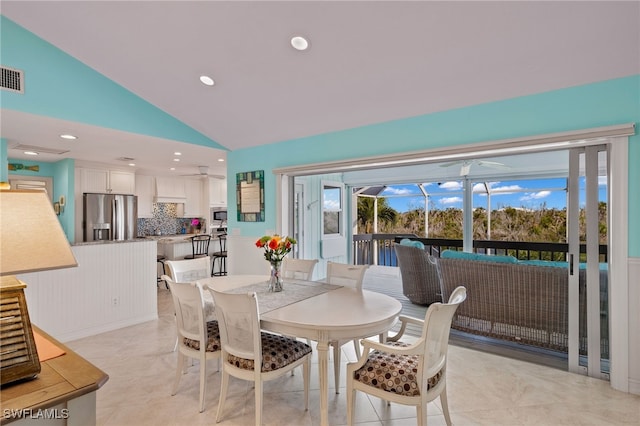 dining area featuring ceiling fan and high vaulted ceiling