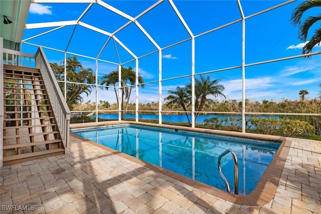 view of pool with a lanai, a water view, and a patio