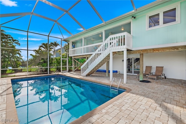 view of swimming pool featuring a lanai, ceiling fan, and a patio area