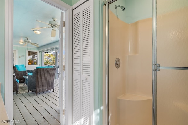 bathroom with an enclosed shower, ceiling fan, and wood-type flooring