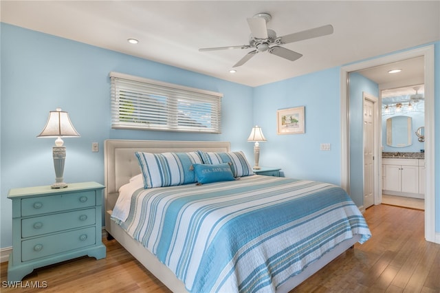 bedroom with ceiling fan, connected bathroom, and light wood-type flooring