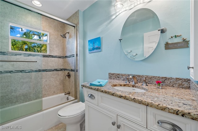 full bathroom with shower / bath combination with glass door, vanity, and toilet