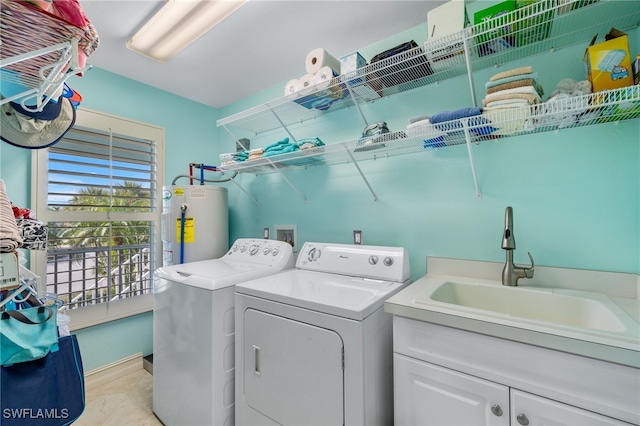 washroom featuring cabinets, sink, washing machine and dryer, and water heater