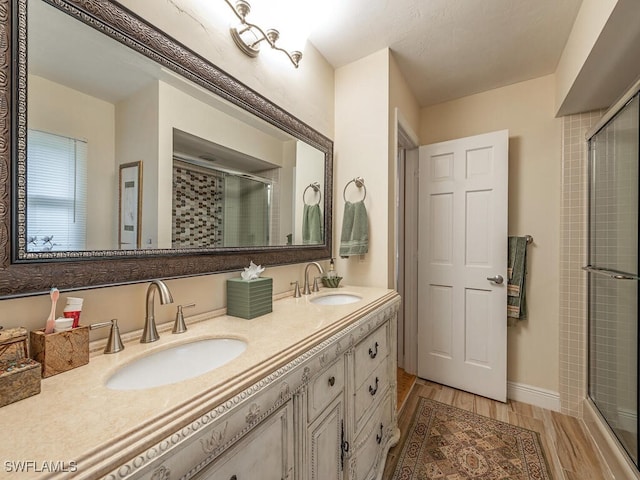 bathroom featuring vanity, hardwood / wood-style floors, and a shower with door