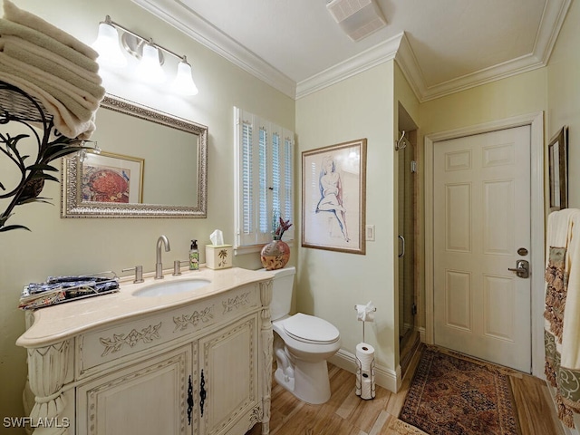 bathroom with toilet, an enclosed shower, wood-type flooring, ornamental molding, and vanity