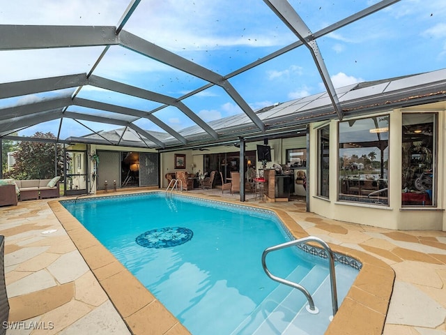 view of swimming pool featuring a lanai, a patio area, and an outdoor living space