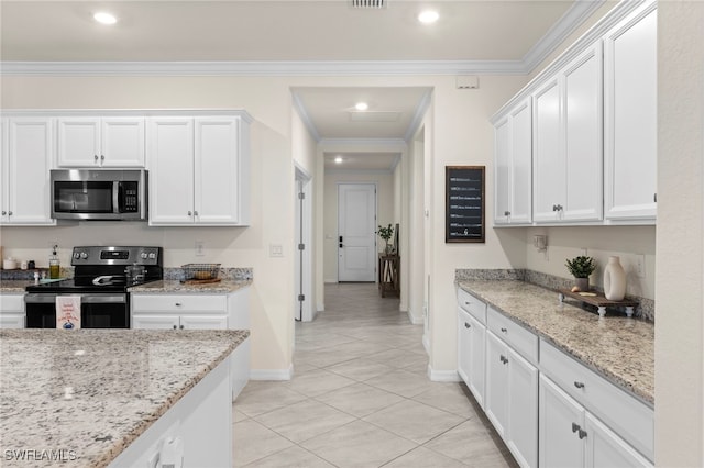 kitchen with crown molding, appliances with stainless steel finishes, white cabinets, light stone counters, and light tile patterned flooring