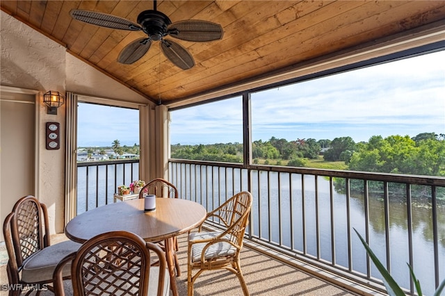 sunroom / solarium featuring wood ceiling, ceiling fan, lofted ceiling, and a water view