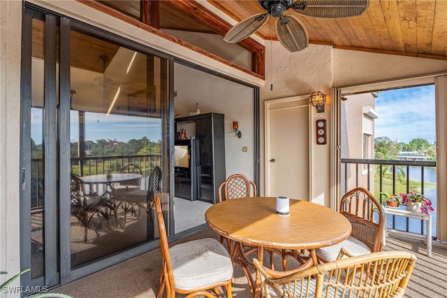 interior space with a water view, vaulted ceiling, ceiling fan, and wood ceiling