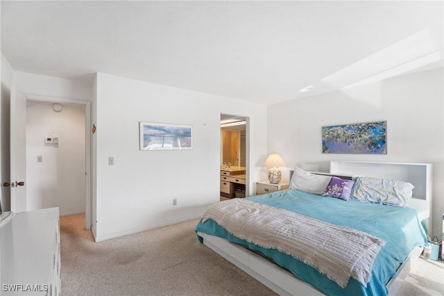 bedroom with light colored carpet and ensuite bath