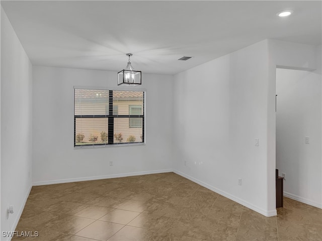 tiled empty room with an inviting chandelier