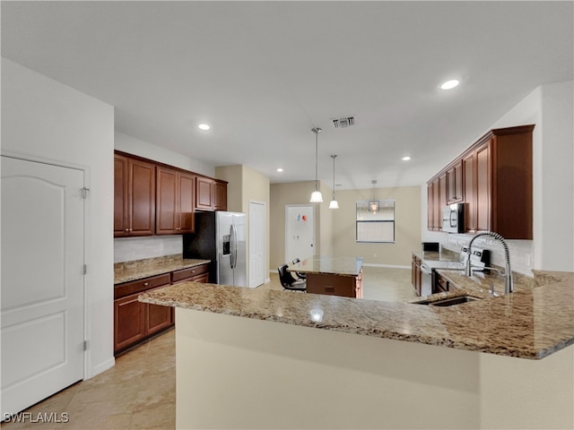 kitchen featuring stainless steel appliances, a center island, light stone countertops, pendant lighting, and sink