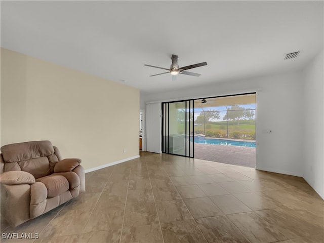 spare room with ceiling fan and light tile patterned floors