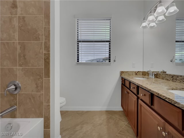 bathroom featuring plenty of natural light, tile patterned floors, toilet, and vanity