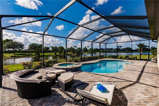 view of pool with a patio area, glass enclosure, a water view, and an in ground hot tub