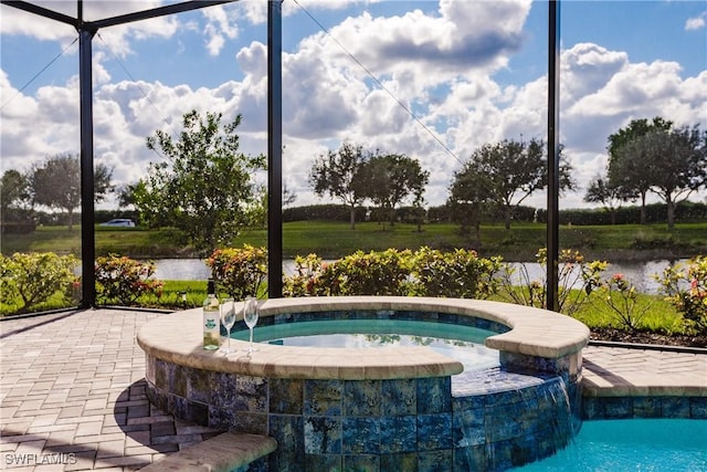 view of swimming pool with a water view, pool water feature, and an in ground hot tub