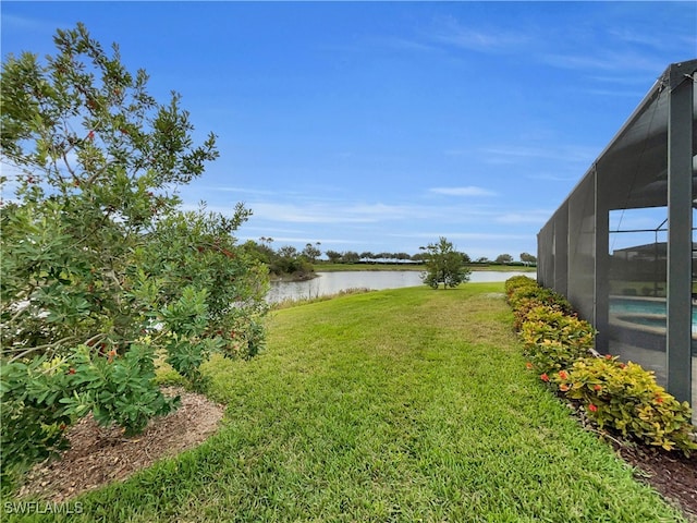 view of yard with a water view and glass enclosure