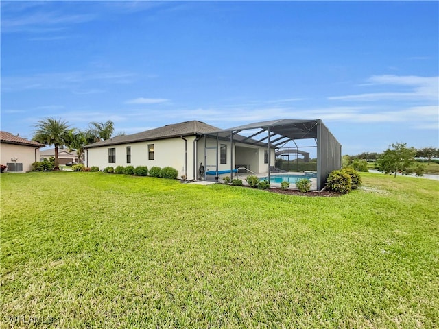 back of house with a lanai, central AC, and a lawn